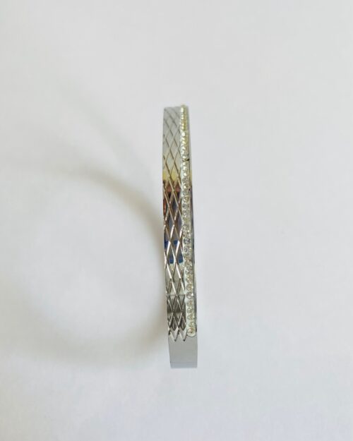 Sleek silver bangle with diamond-cut texture and elegant stone detailing - Image 6