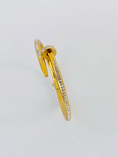 Elegant gold-tone anti-tarnish bracelet styled like a nail, adorned with shimmering stones.
